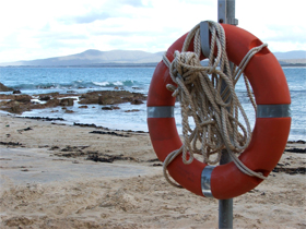 Life preserver on post beside beach/ocean